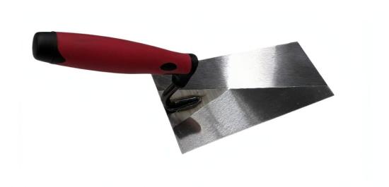 Kelle mit rotem Griff zum Überdecken der Kappen mit Beton in der Produktion von Thermowänden und Doppelwänden im Betonfertigteilwerk